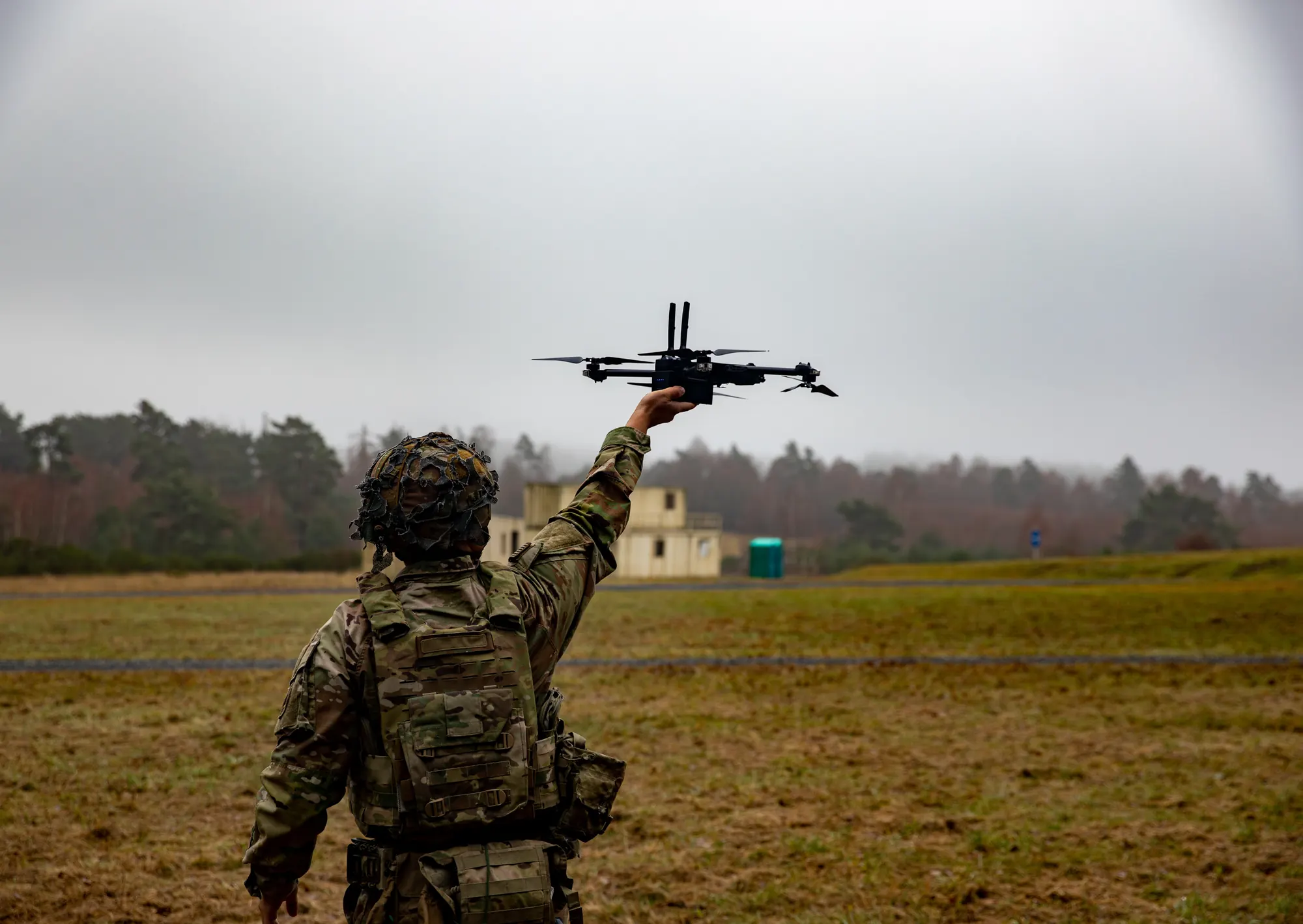 Soldier launching a small drone in fog